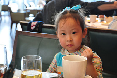 Portrait of cute boy drinking glasses on table at restaurant