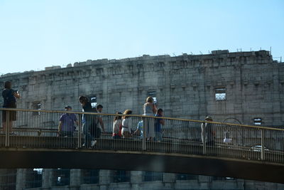 People on bridge against clear sky