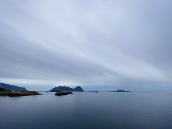 Scenic view of sea and mountains against sky