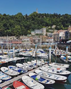 Boats moored at harbor against sky