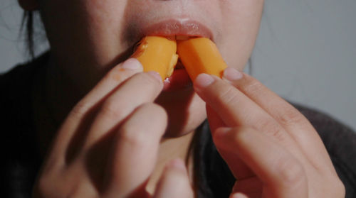 Cropped hand of woman eating food