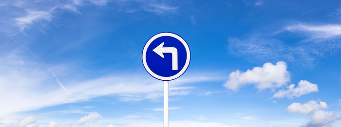 Low angle view of road sign against sky