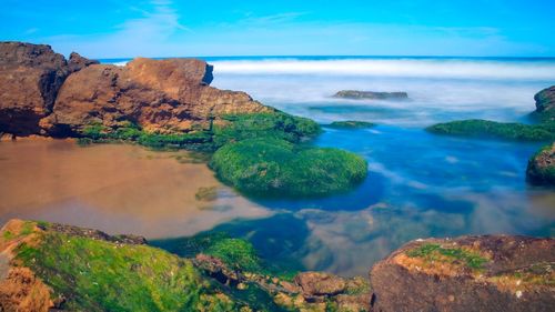 Panoramic view of rocks on beach against sky