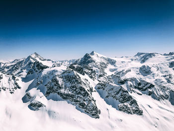 Scenic view of snowcapped mountains against clear blue sky