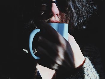 Close-up portrait of woman holding cup