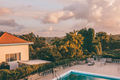 Houses by swimming pool against sky