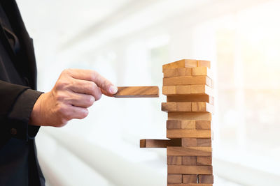 Cropped hand of man making wooden block stack