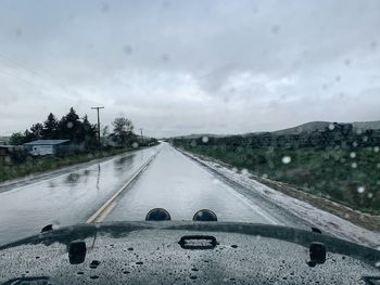 Wet road against sky during rainy season