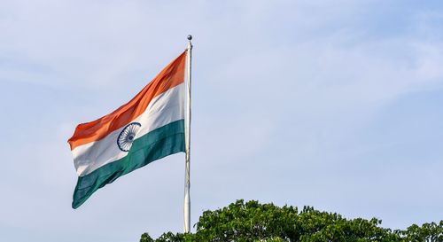 Low angle view of flag flags against sky