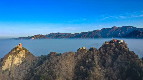 Panoramic view of sea and mountains against blue sky