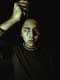 Portrait of young man against black background