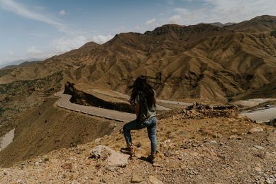 Full length of senior woman walking on mountain against sky