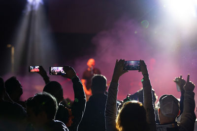 Group of people photographing at music concert
