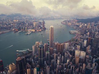 Aerial view of modern buildings in city against cloudy sky