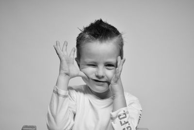 Portrait of cute boy against gray background