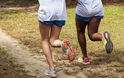 Low section of women running on dirt road