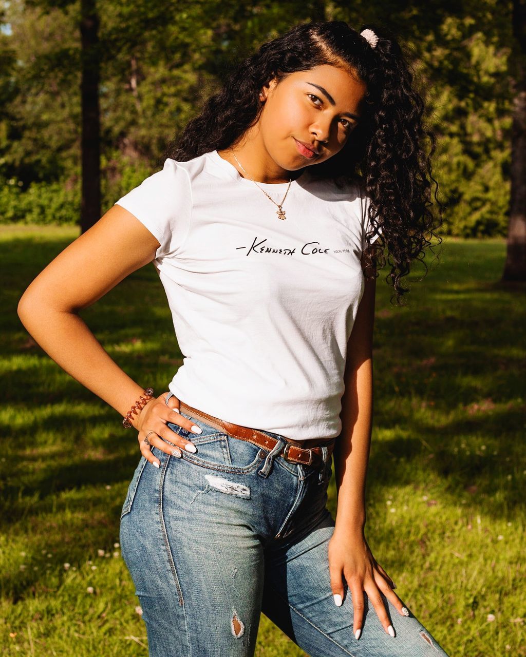 one person, young adult, real people, casual clothing, young women, hair, three quarter length, hairstyle, front view, lifestyles, plant, leisure activity, standing, women, day, nature, tree, curly hair, focus on foreground, beautiful woman, jeans, outdoors, teenager