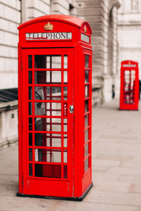 Red telephone booth on footpath