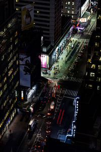 Traffic on city street amidst buildings at night