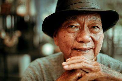 Close-up portrait of smiling senior man sitting in cafe