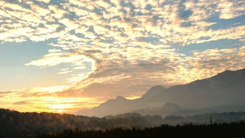 Scenic view of silhouette mountains against sky at sunset