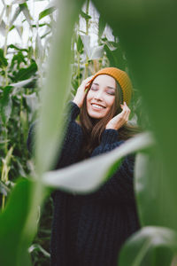 Young woman with eyes closed amidst plants