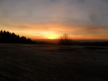 Scenic view of snow covered land during sunset