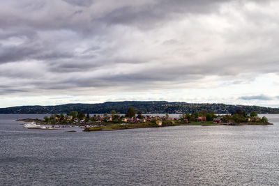 Scenic view of sea by city against sky