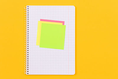 Close-up of yellow paper over colored background