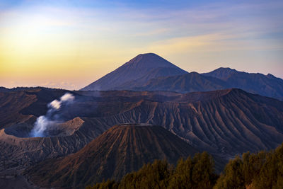 Scenic view of volcanic mountain against sky during sunset