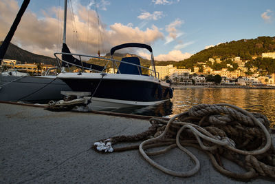 Sailboats moored at harbor against sky