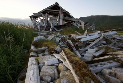 Damaged house against mountains