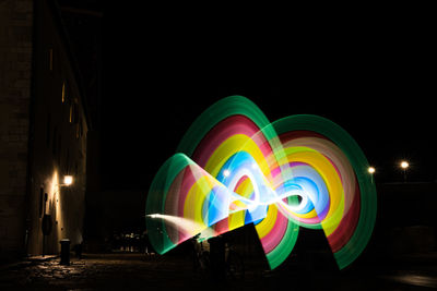 Multi colored light painting against sky at night
