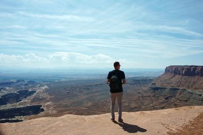 Rear view of man standing on rock