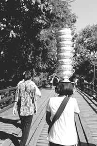 Rear view of men walking on sidewalk