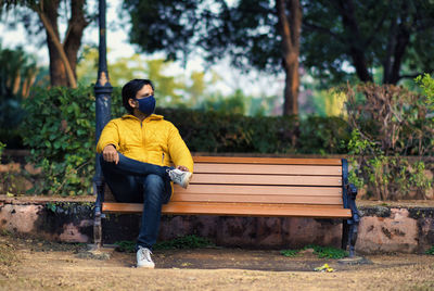 Young man sitting on bench at park