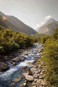 Scenic view of river and mountains against sky