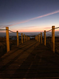 Wooden pier on sea against sky during sunset