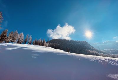 Scenic view of snowcapped mountains against blue sky