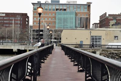 Footbridge over canal amidst buildings in city