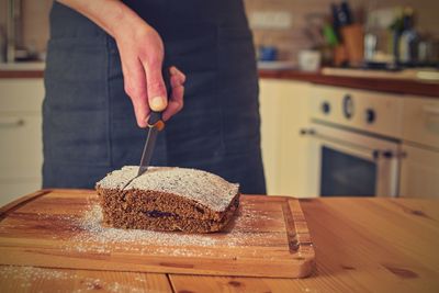 Man cutting classic gingerbreads in decorated kitchen. a classic gingerbread recipe. family home.