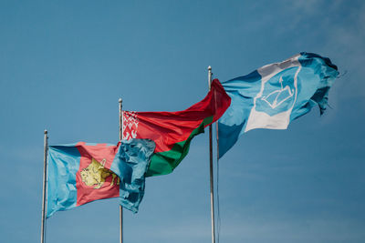 Low angle view of flags flag against blue sky