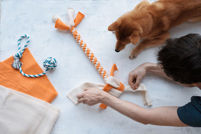 Adult man making diy homemade educational toys for dogs using a tutorial from the internet