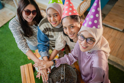 Portrait of smiling young woman standing against wall