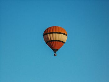 Low angle view of hot air balloon against clear blue sky