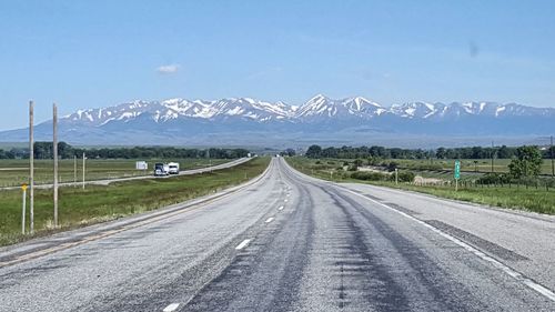 Road by mountains against sky