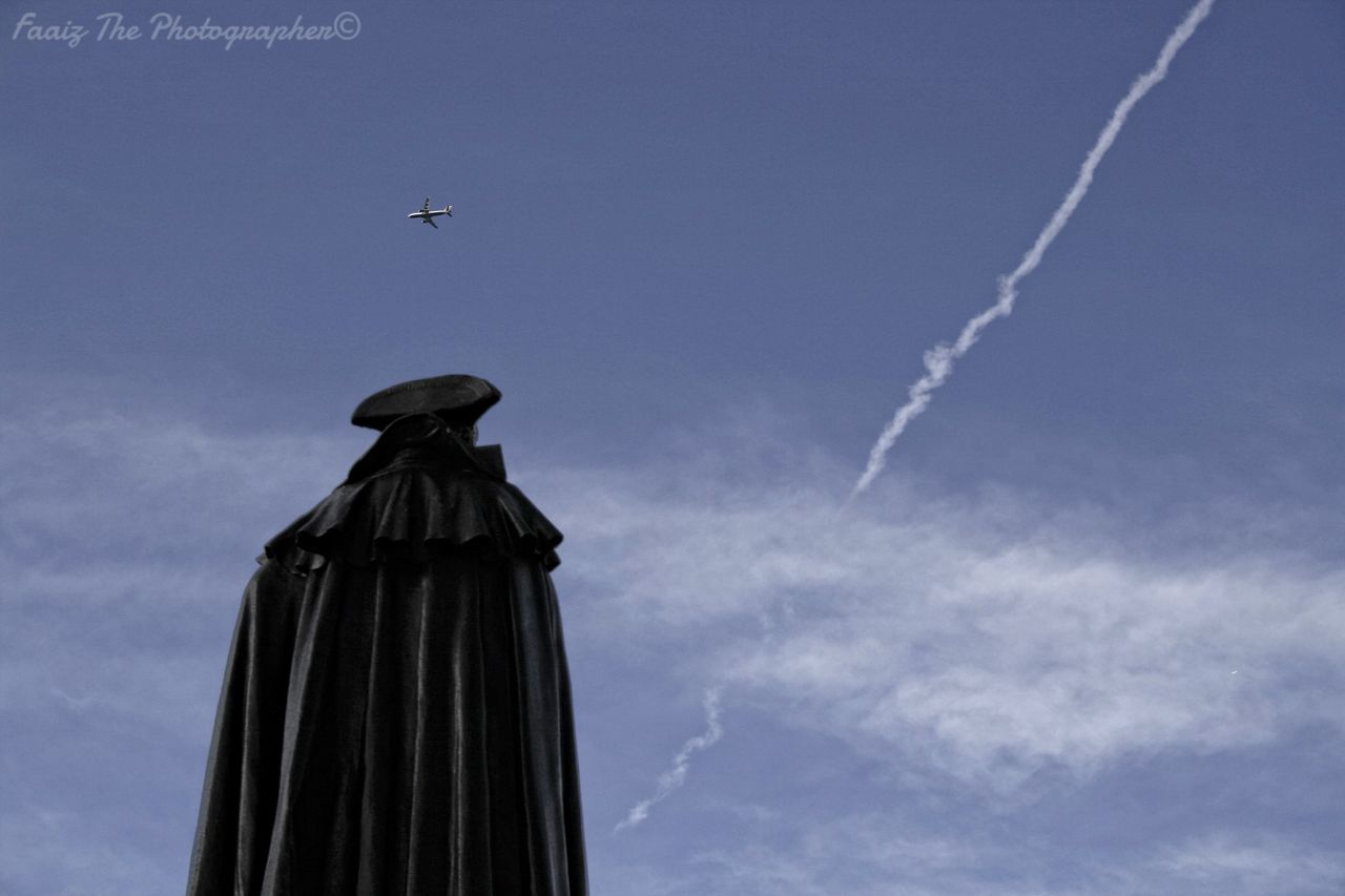 low angle view, statue, sky, sculpture, human representation, built structure, architecture, building exterior, cloud - sky, blue, art and craft, high section, art, cloud, travel, outdoors, no people, day, famous place