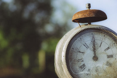 Close-up and detail of old weathered and dirty vintage retro clock showing midnight or noon. 12h.