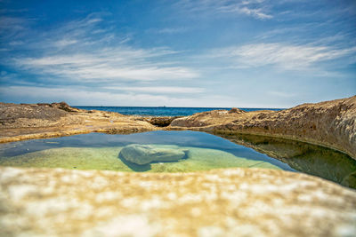 Surface level of rocks on beach against sky