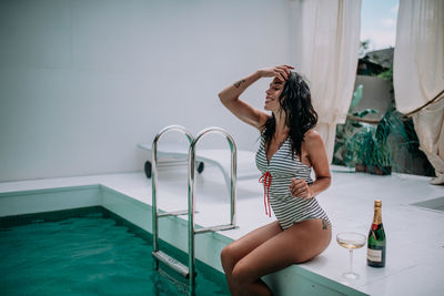 Full length of woman sitting in swimming pool